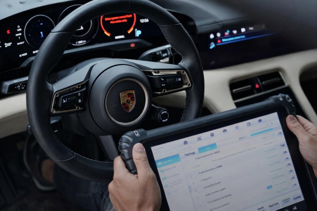 車內以平板進行系統診斷與車況檢視，方向盤與數位儀表顯示專業檢測情境